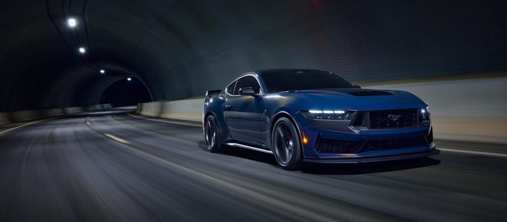 blue mustang dark horse driving on the road