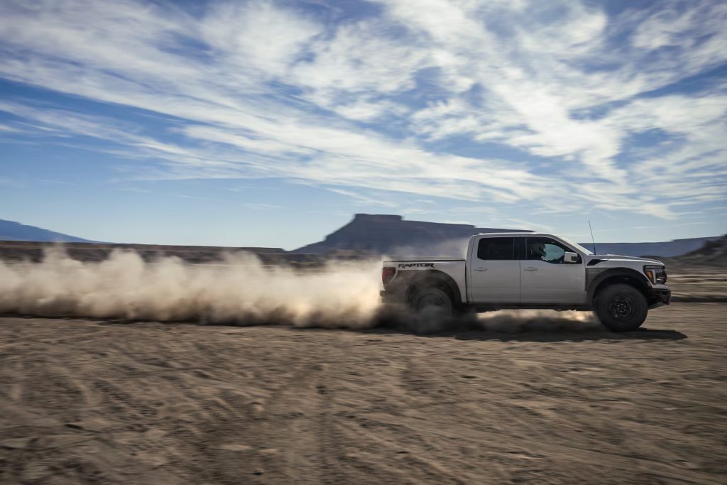 silver ford raptor on the sand
