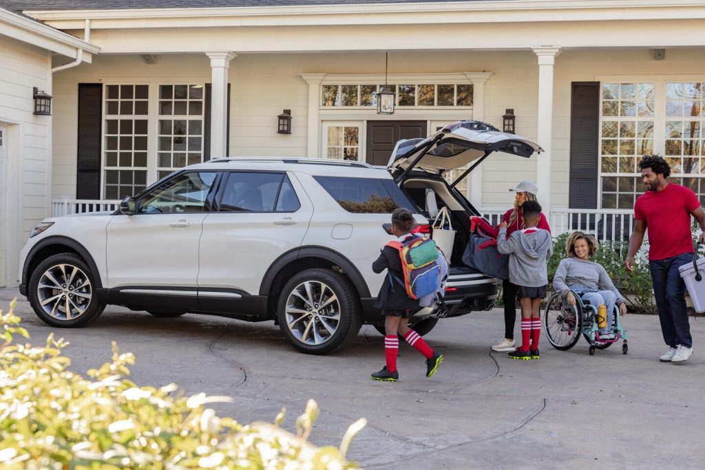 family getting into a white ford explorer 